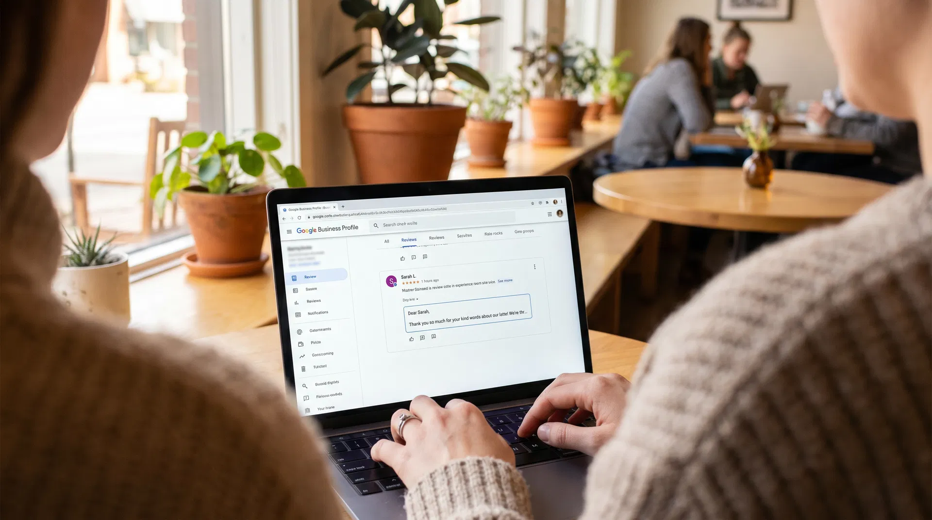 Marketing professional reviewing and responding to Google reviews on a laptop in a modern Sarasota office