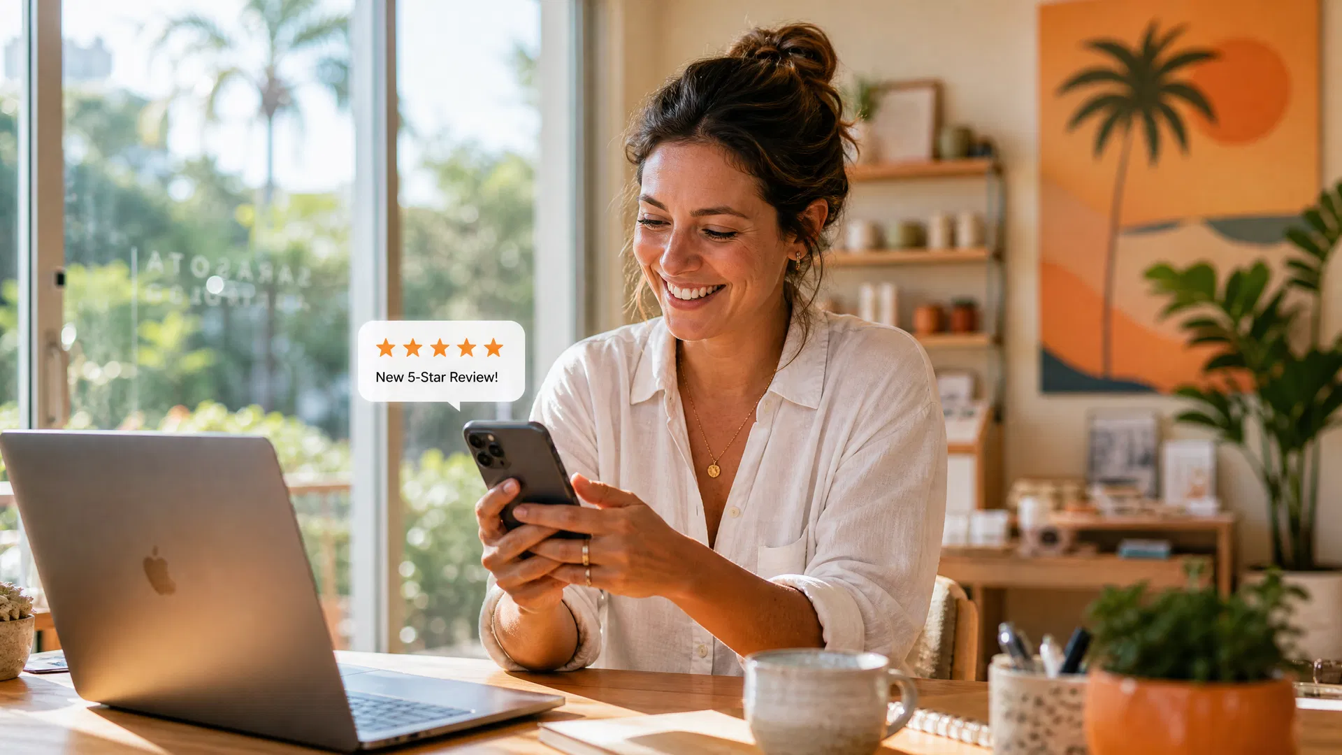 Sarasota small business owner smiling while checking a new 5-star Google review notification on her phone at a bright, modern workspace