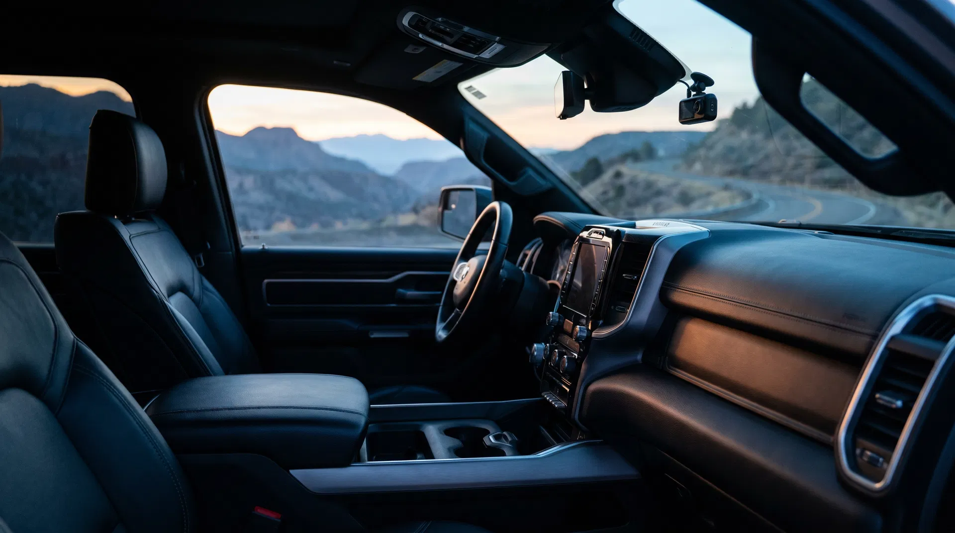 Dark premium truck interior at dawn with a discreet dashcam and a quiet Utah road beyond the windshield