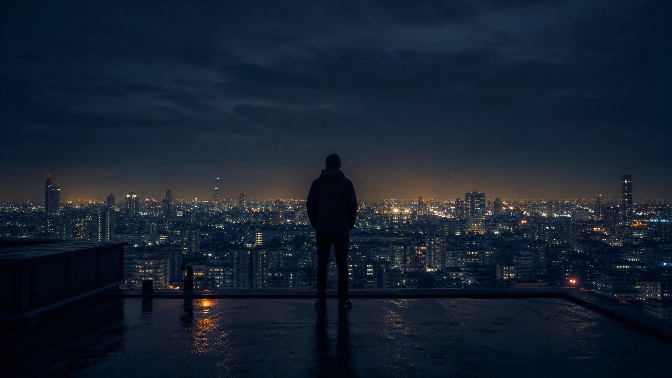 Lone figure standing on a rooftop overlooking a dark city at night — representing the weight of sustained high performance