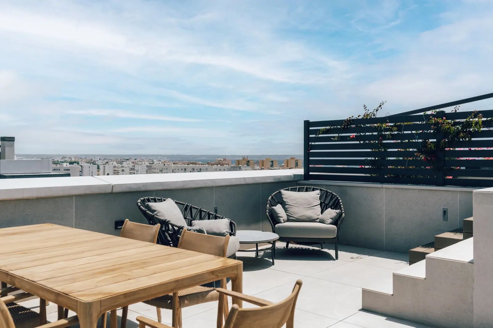 Rooftop terrace with dining table and views over Palma towards the sea