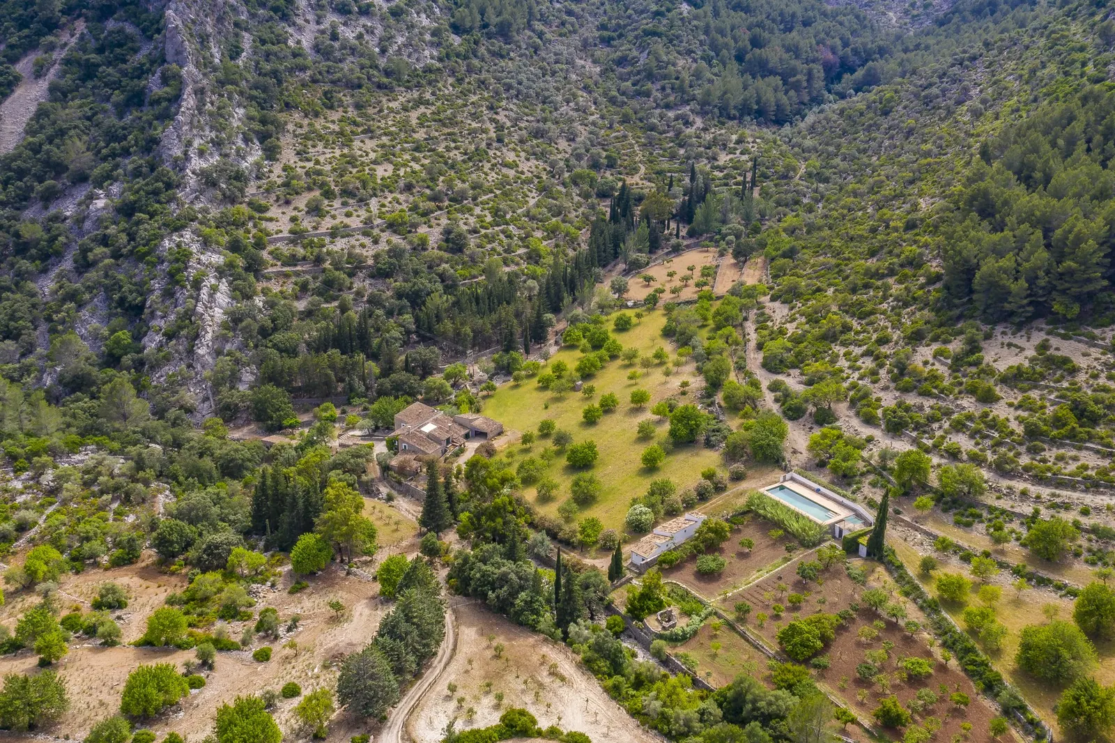 Aerial view of a historic country house surrounded by forest and mountains near Selva