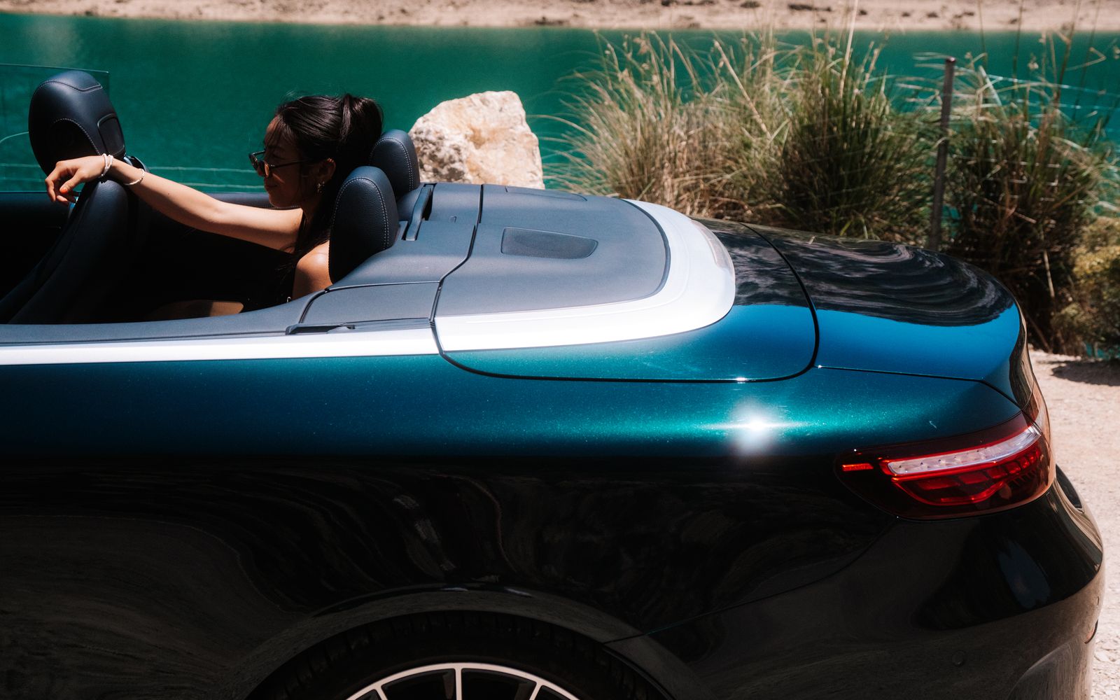 Mercedes-Benz E-Class Cabriolet verde oscuro junto a un embalse de montaña en Mallorca
