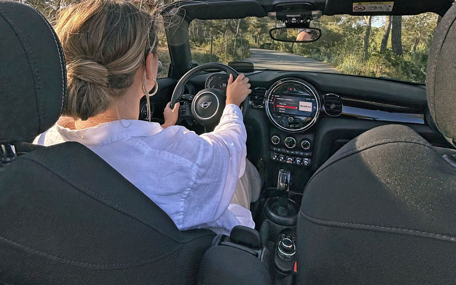 Езда на Mini Cooper S Cabrio со сложенной крышей среди сосен на Mallorca