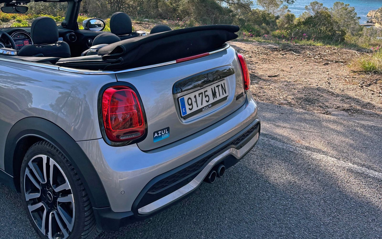 Silberner Mini Cooper S Cabrio an der Küste auf Mallorca geparkt