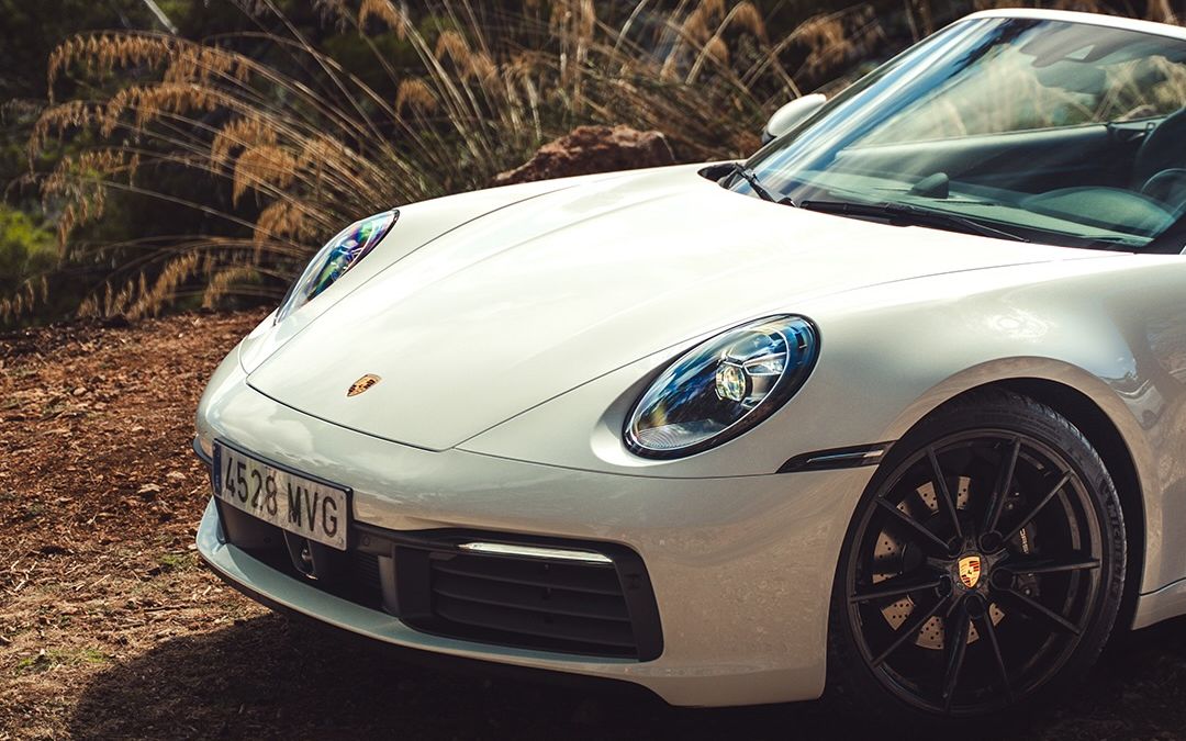 Vit Porsche 911 Carrera Cabriolet bredvid tallar på Mallorca