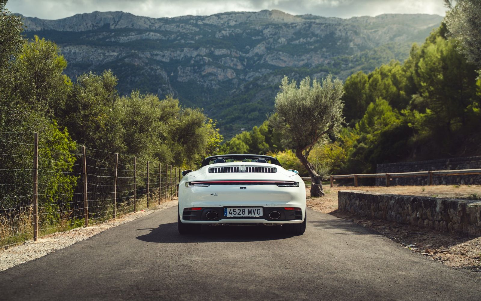 Vit Porsche 911 Carrera Cabriolet på en bergsväg på Mallorca