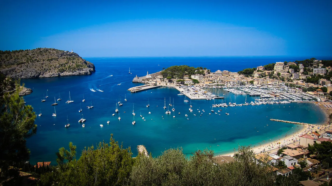 Aerial view of yachts in Port de Sóller bay, with the marina and beach visible.