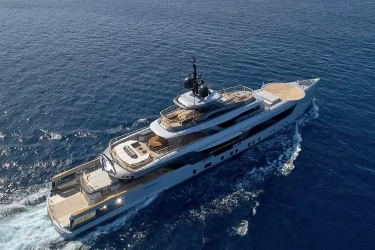 A sleek luxury motor yacht cruising in open water, viewed from above with no people visible.