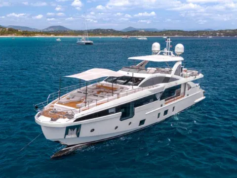 Aerial view of a large white luxury motor yacht anchored in an unidentified coastal bay