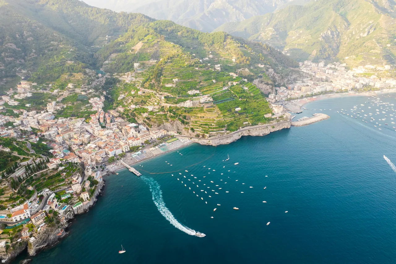 Aerial view of the Amalfi Coast with a superyacht anchored near Positano