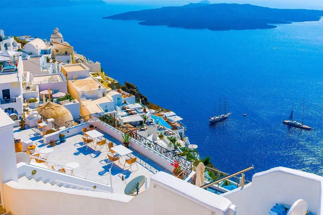 Santorini caldera view with luxury yacht anchored in the Aegean Sea