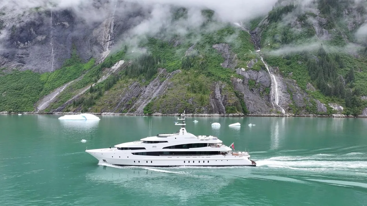 Explorer yacht navigating through a Norwegian fjord with dramatic mountain scenery
