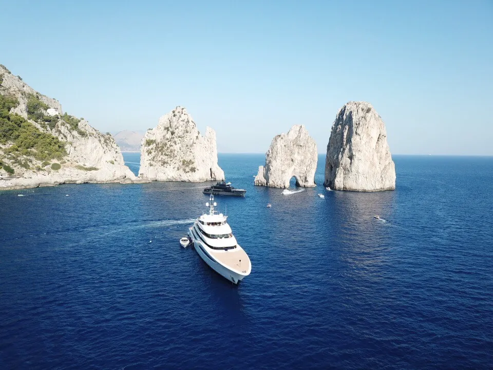 Aerial view of luxury motor yachts near the Faraglioni rocks off Capri, Italy.