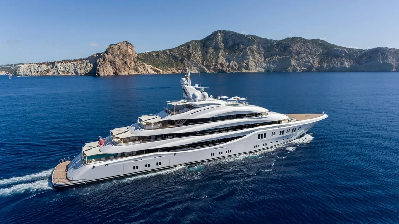 Aerial view of luxury motor yacht Lady E cruising beside a rocky coastline.