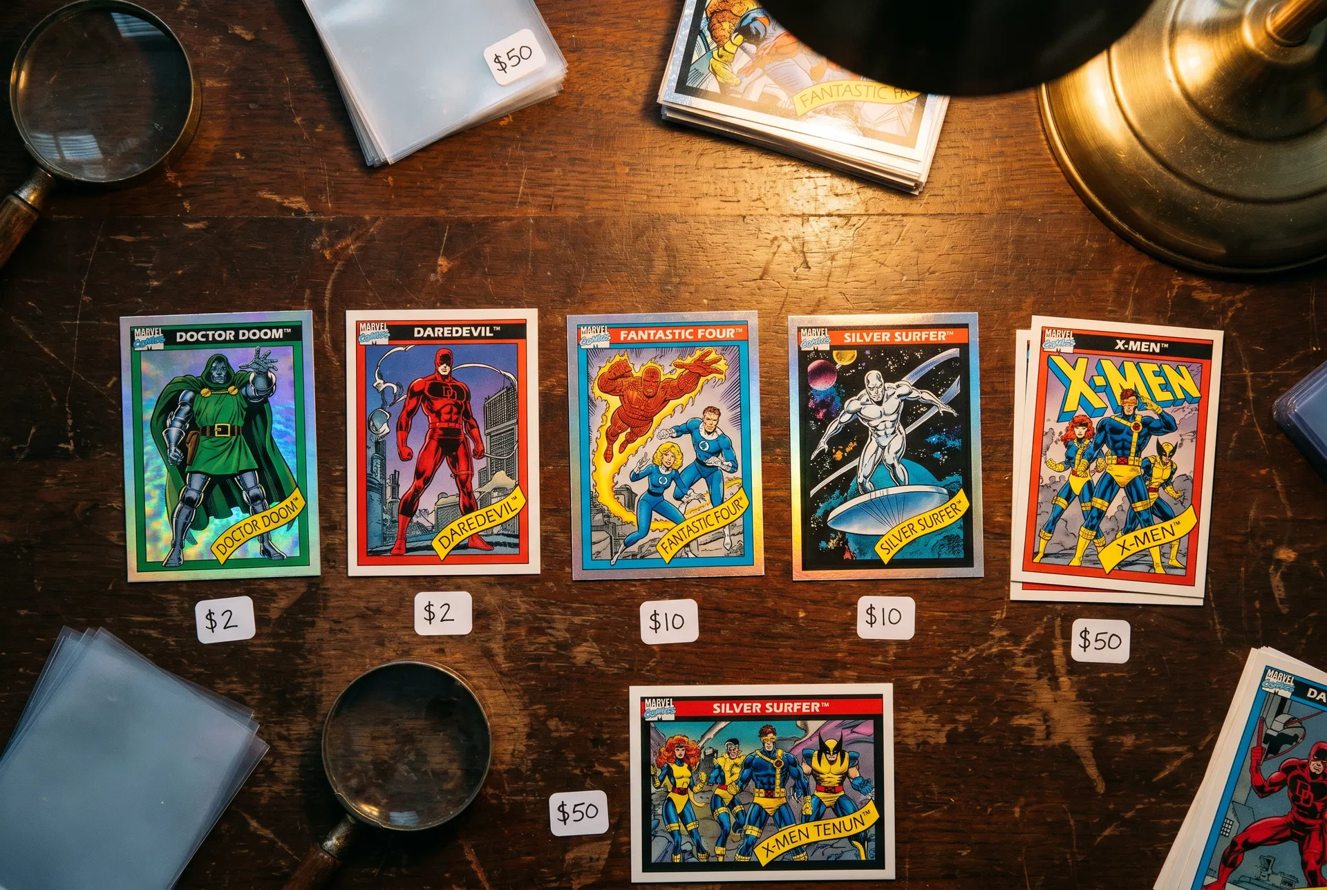Vintage Marvel trading cards featuring Doctor Doom, Daredevil, Fantastic Four, Silver Surfer, and X-Men on a collector desk