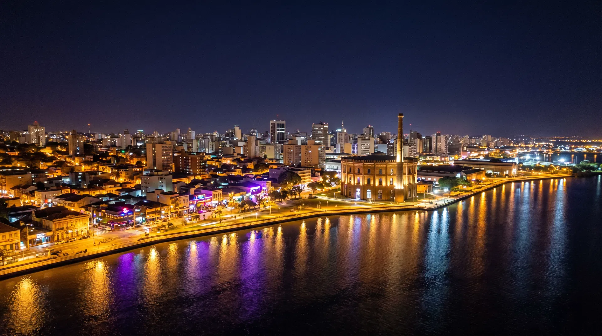 Aerial night view of Porto Alegre waterfront with the Gasômetro cultural center and Guaíba lake reflecting city lights