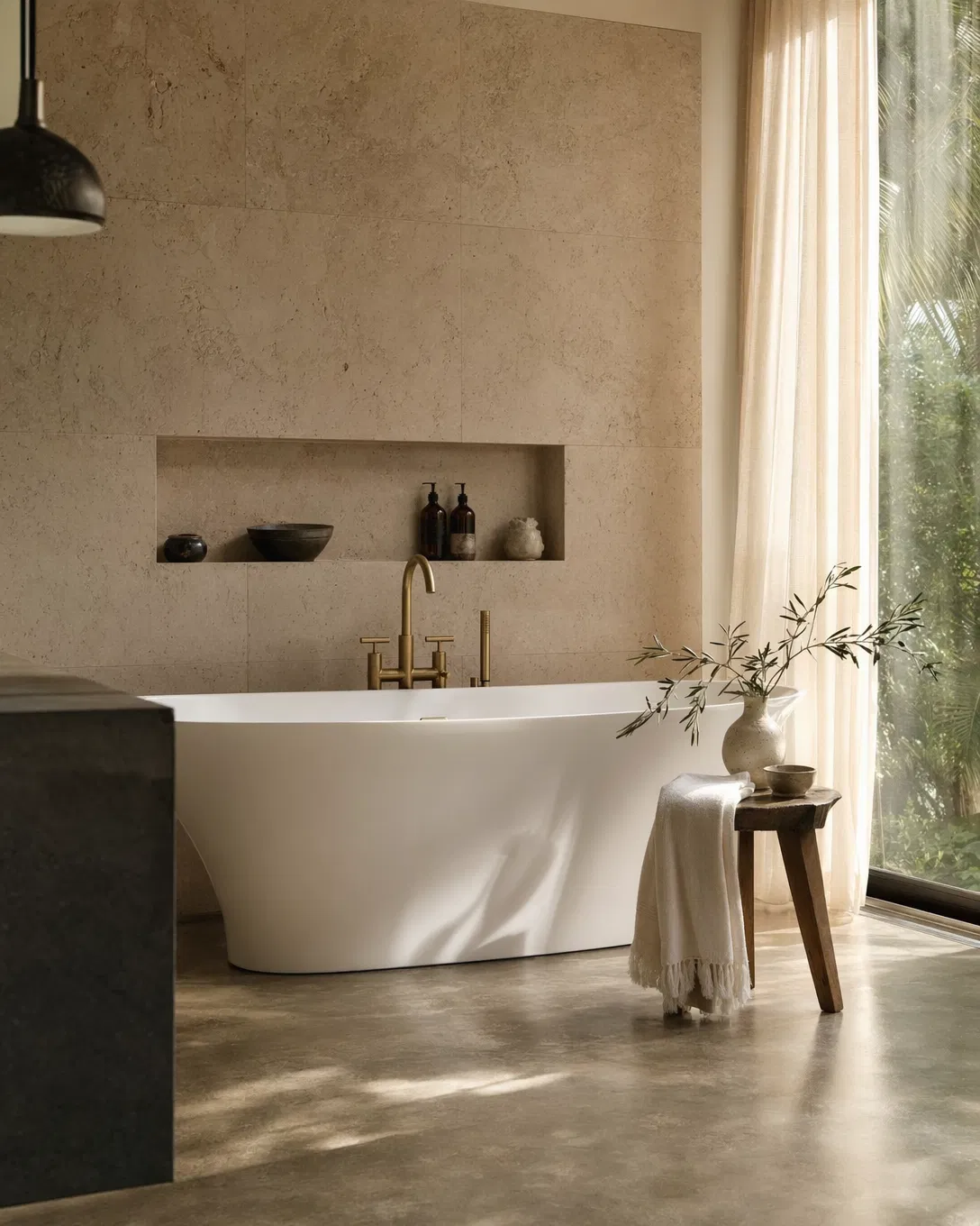 Remodeled bathroom with travertine wall and brushed brass fixtures