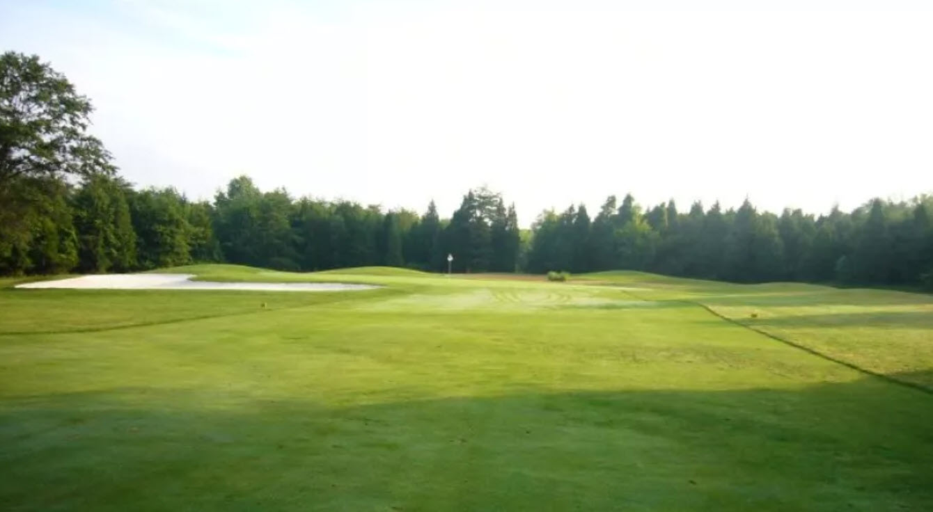 Scenic view of a lush green fairway at Brambleton Golf Course with mature trees and blue skies in Ashburn, Virginia