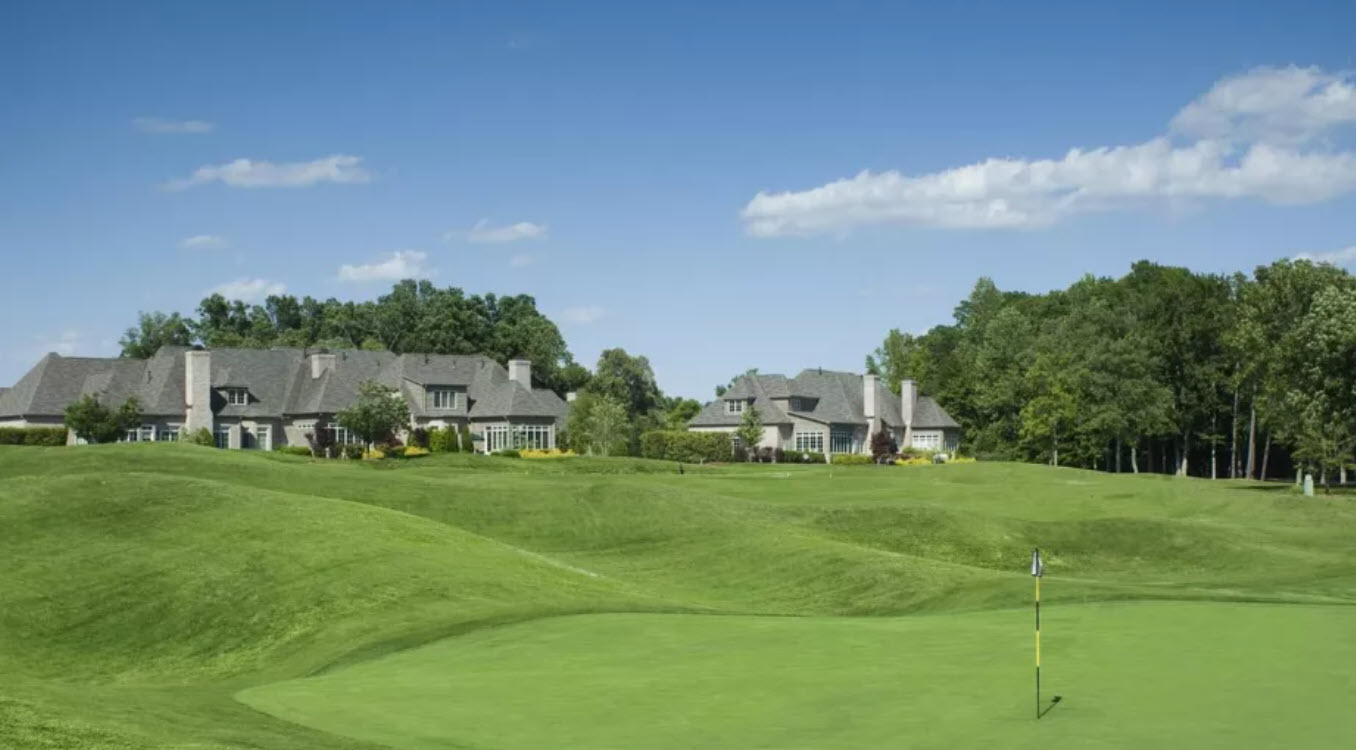 Scenic view of the 18th hole at Grandover Resort East Course with water hazard and clubhouse in the background