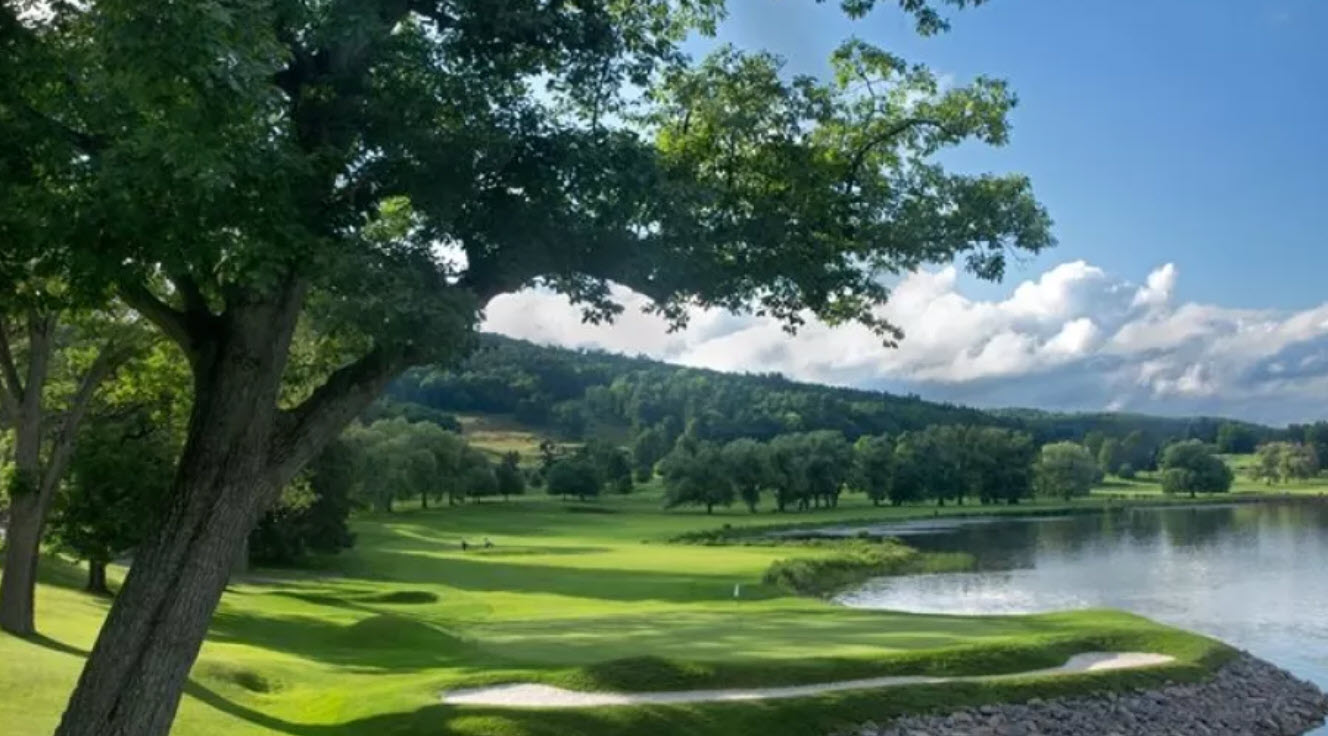 Panoramic view of Leatherstocking Golf Course with Otsego Lake and the Otesaga Resort Hotel in the background