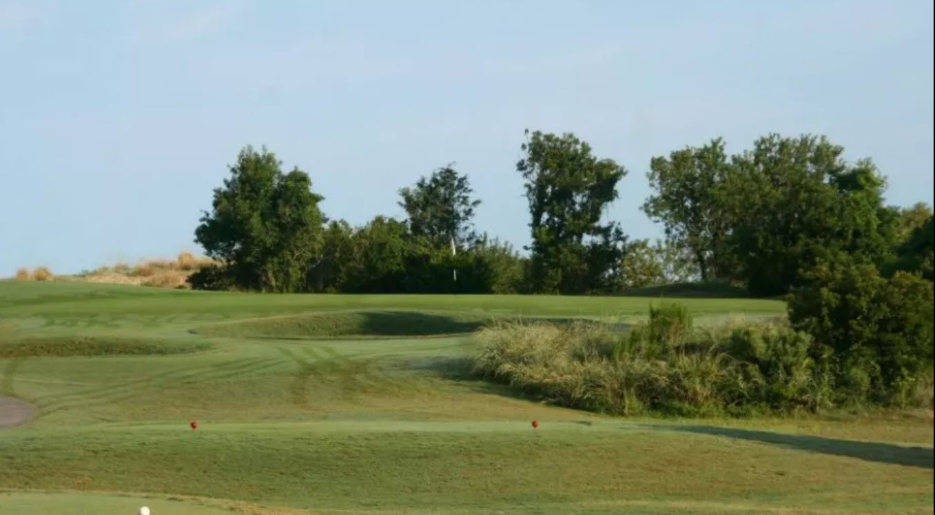 Scenic view of Nags Head Golf Links with the Roanoke Sound in the background and golfers on a green