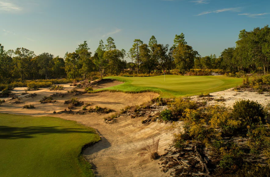 Aerial view of Ohoopee Match Club golf course with wide fairways and sandy waste areas under a clear sky.