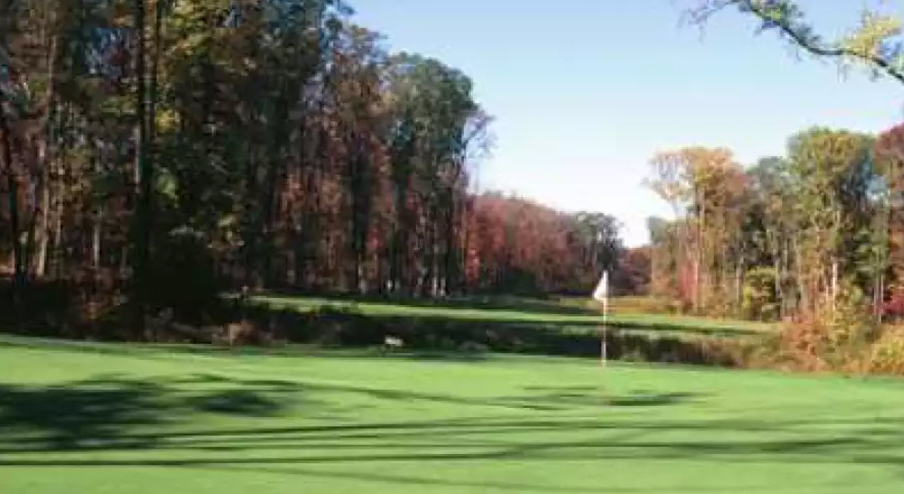 Panoramic view of Olde Homestead Golf Club with rolling hills, green fairways, and a clear sky