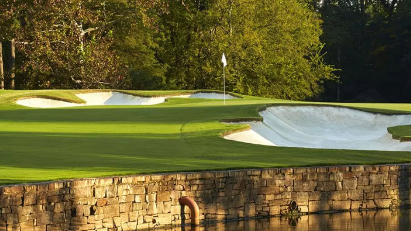 Aerial view of the 17th hole at Quail Hollow Club with water guarding the green and lush green fairways.