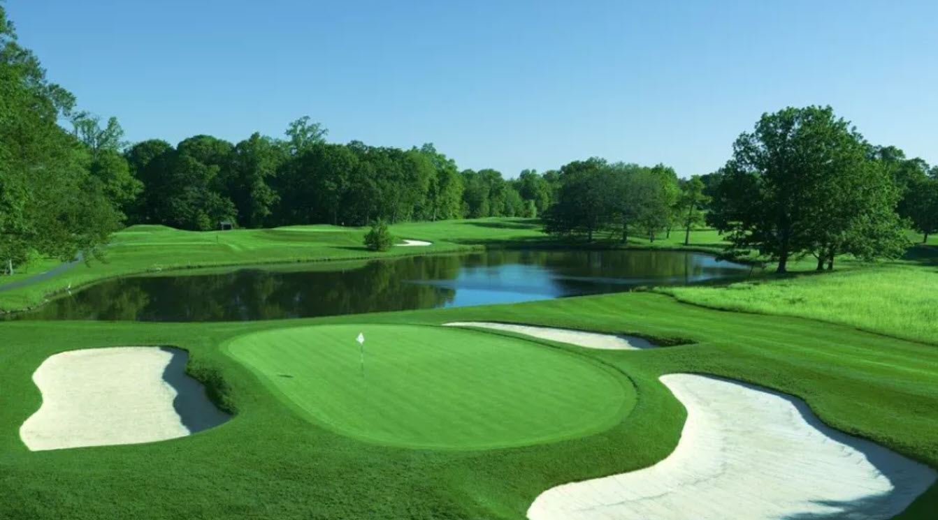 Aerial view of a challenging par-3 hole at Quaker Ridge Golf Club with bunkers and water hazards