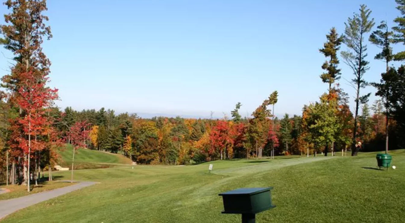 Panoramic view of a green and fairway at Saratoga Lake Golf Club with Saratoga Lake in the background