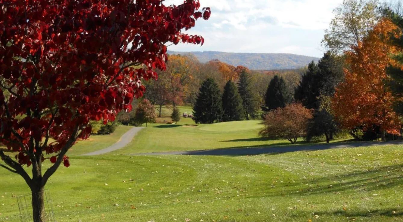 Panoramic view of a golf course fairway at Shenandoah Valley Golf Club with mountains in the background