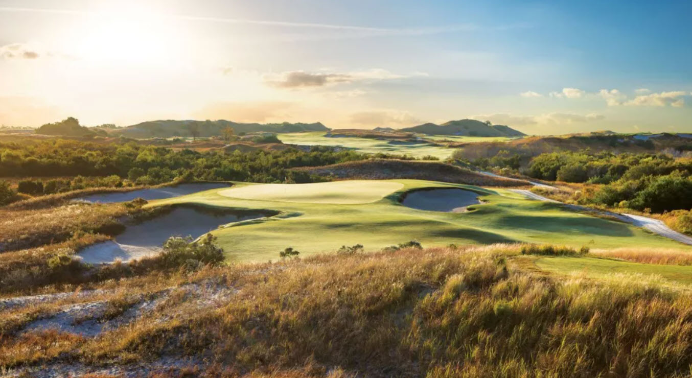 Panoramic view of the Streamsong Red Course with rolling sand dunes and lush fairways under a blue sky.