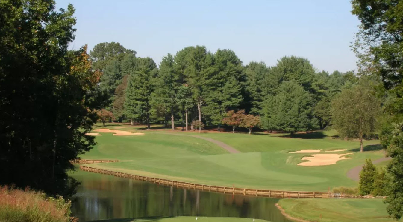 Scenic view of a green and fairway at Tanglewood Park Championship Course with mature trees in the background