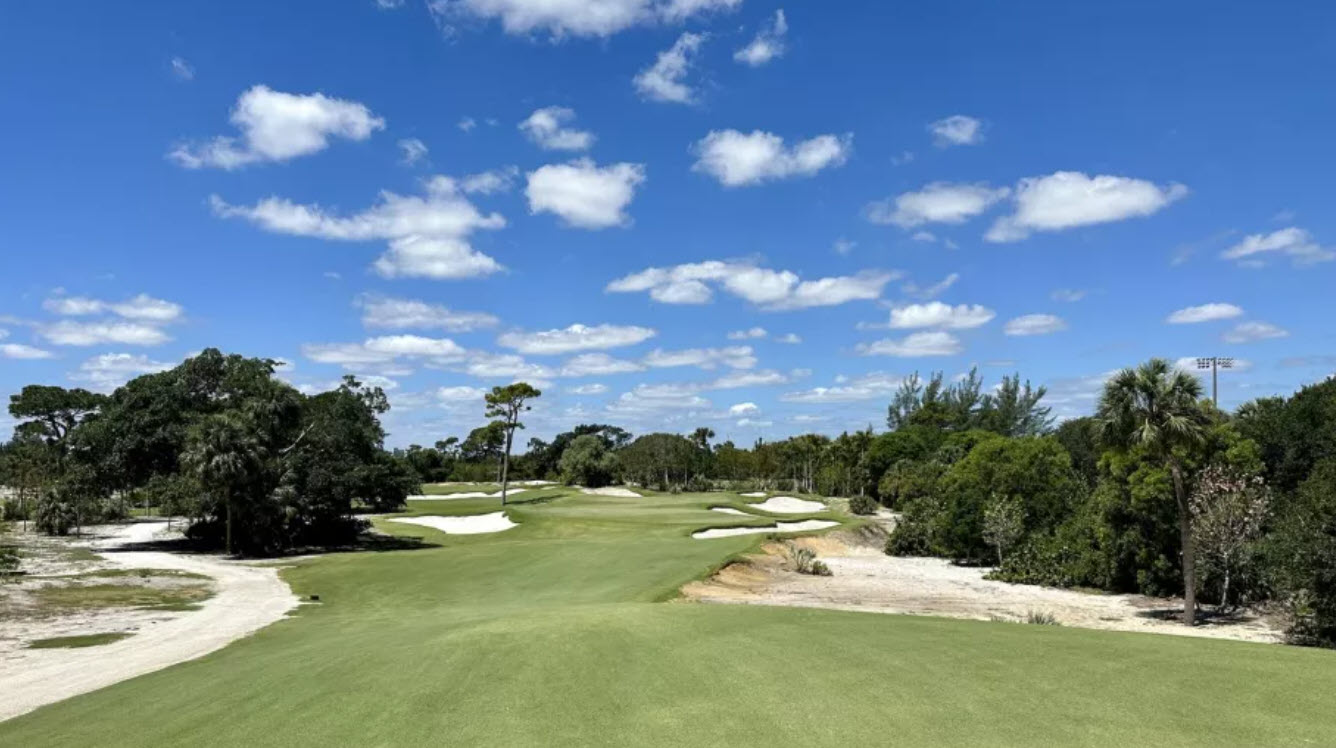 Aerial view of The Park West Palm golf course with lush green fairways and water features under a blue sky