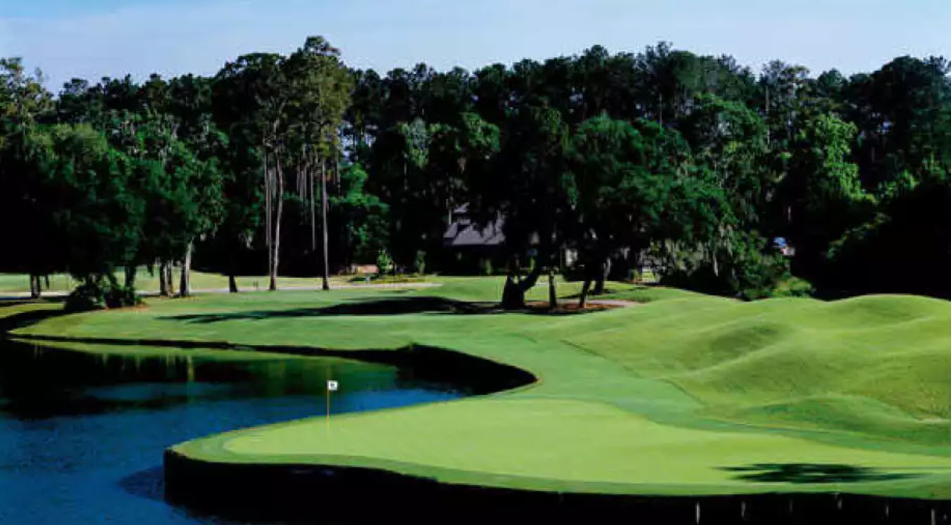 Overview of a hole on Dye's Valley Course at TPC Sawgrass with water hazards and lush green fairways under a blue sky.