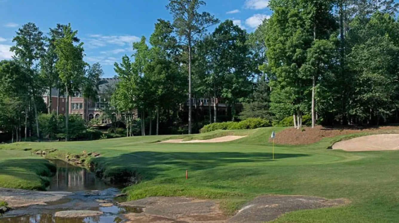Panoramic view of the lush green fairways and pristine clubhouse at TPC Sugarloaf in Duluth, Georgia.