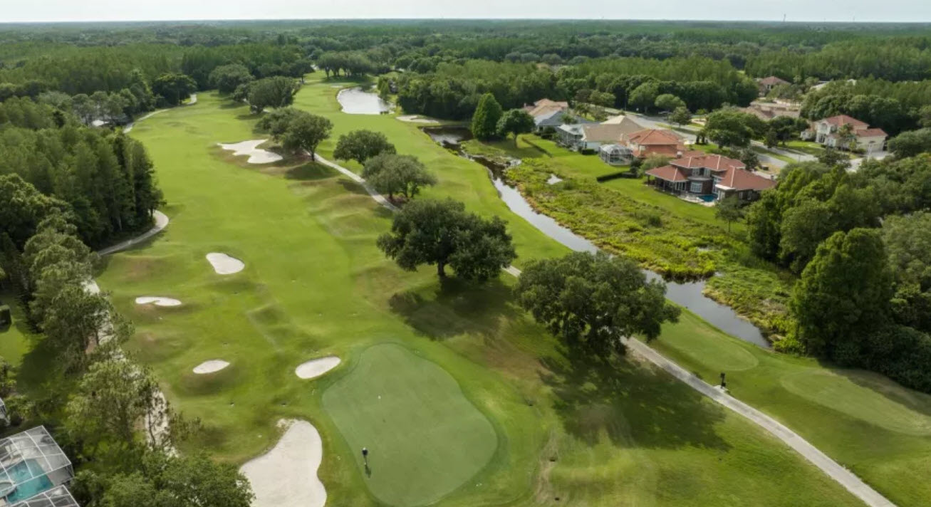 Aerial view of a lush green golf course fairway at TPC Tampa Bay with water hazards and bunkers under a clear blue sky