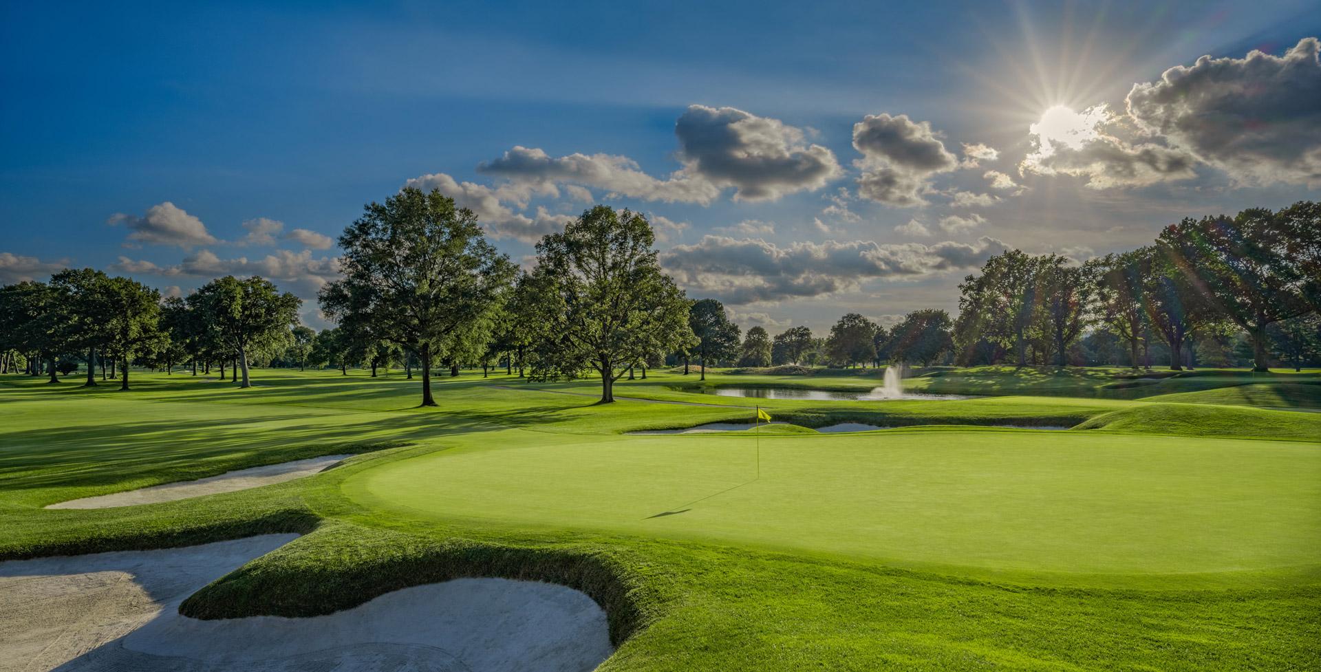 Aerial view of a lush green golf course at Upper Montclair Country Club with mature trees and bunkers