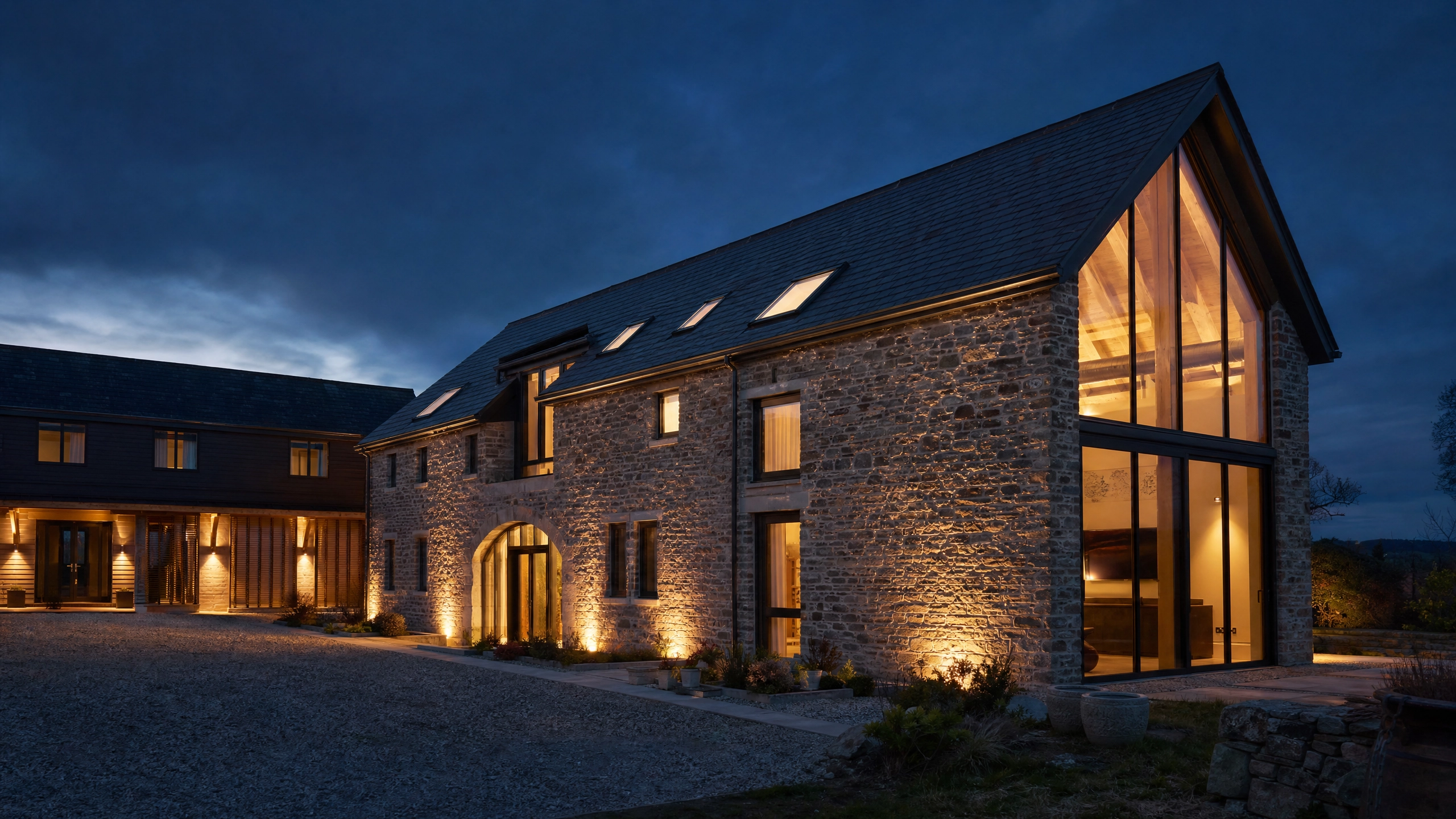 Converted barn property at dusk with dramatic architecture