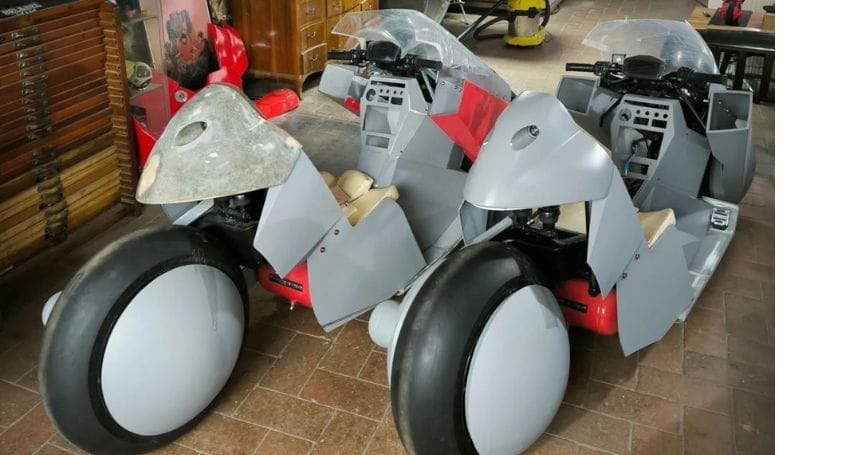 Two motorcycles are parked in a room.