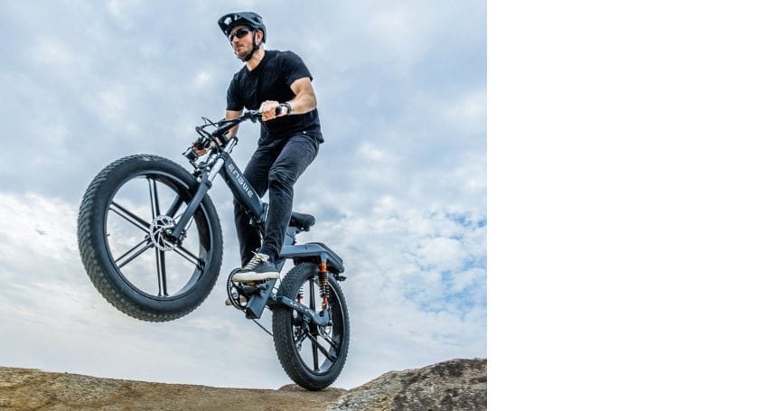 An individual embracing the urban commuting revolution on an electric bike, effortlessly scaling a rock formation.
