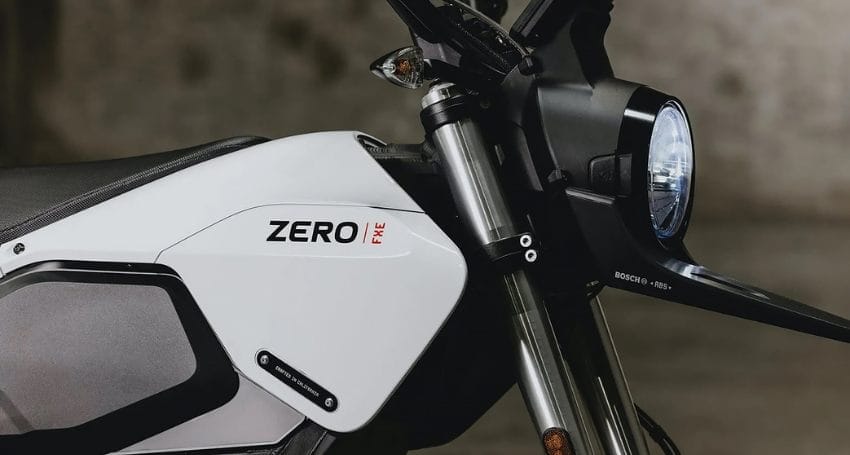 A close up of a motorcycle with the headlight on.