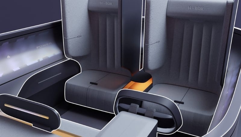 Interior of a modern electric vehicle showing spacious, padded grey seats with streamlined design and surrounding displays.