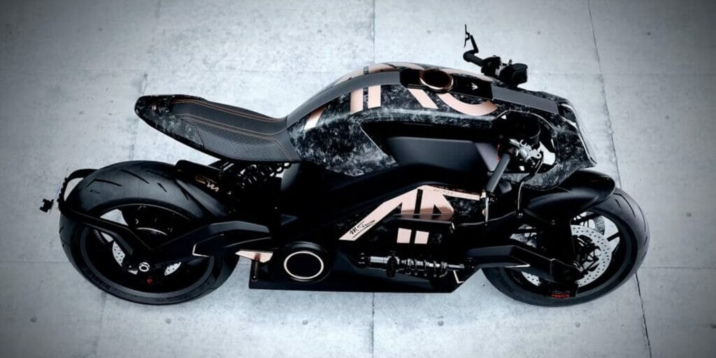 An exclusive black and gold motorcycle, the Arc Founder's Signature Edition Vector, on a sleek concrete floor.