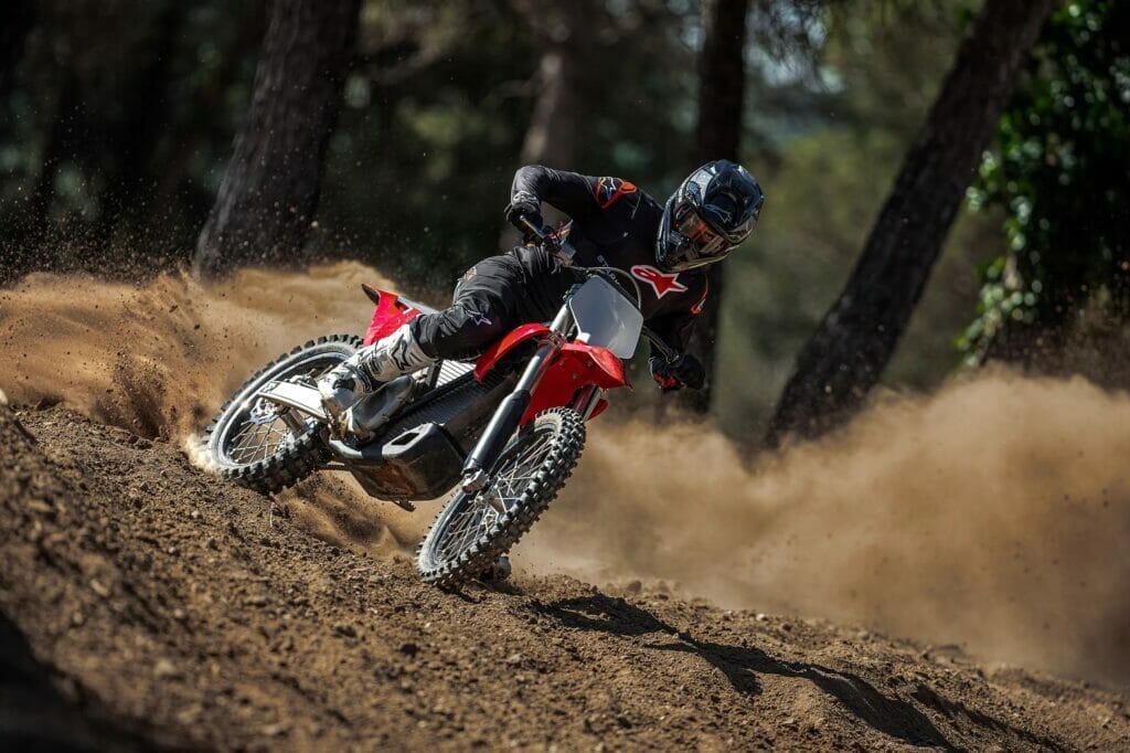 A person riding a red dirt bike.