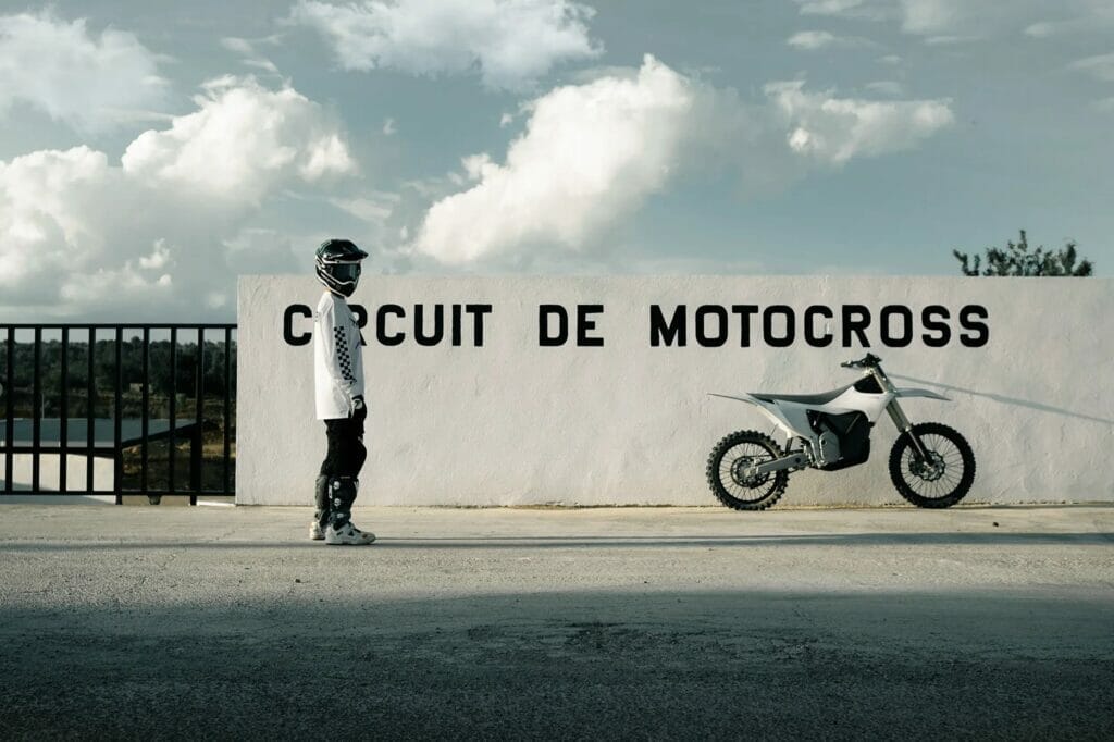 A man is standing next to a sign that says ccut de motocross, and wonders: What's up with Stark Varg Now?