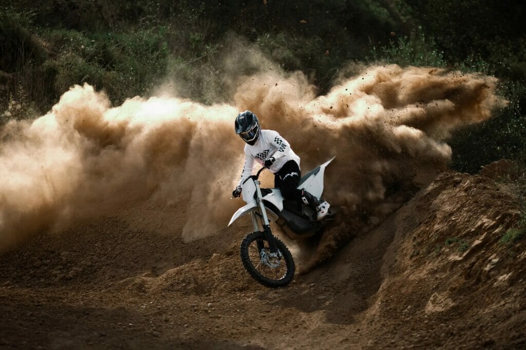 A person riding a dirt bike on a dirt track.