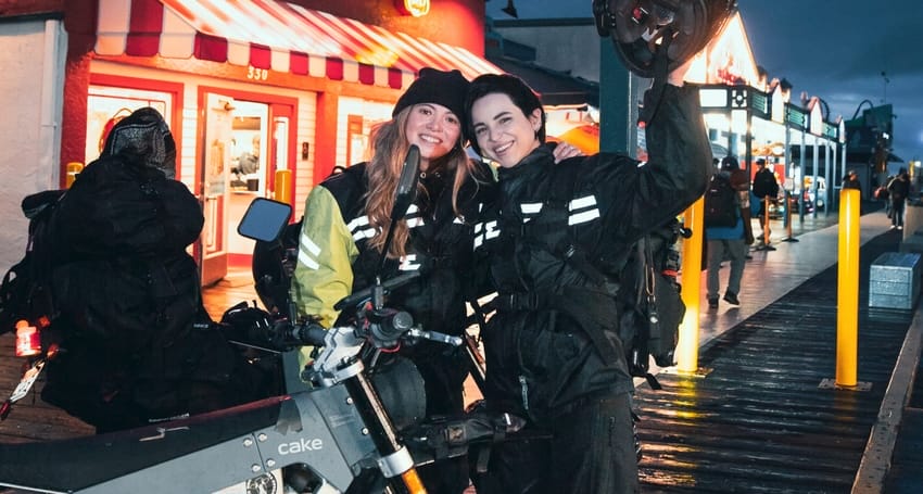 Two people standing next to an <a href=