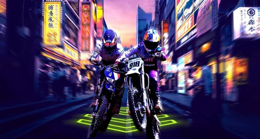 Two motorcyclists from the Honda Racing Corporation team race through a city street adorned with neon lights.